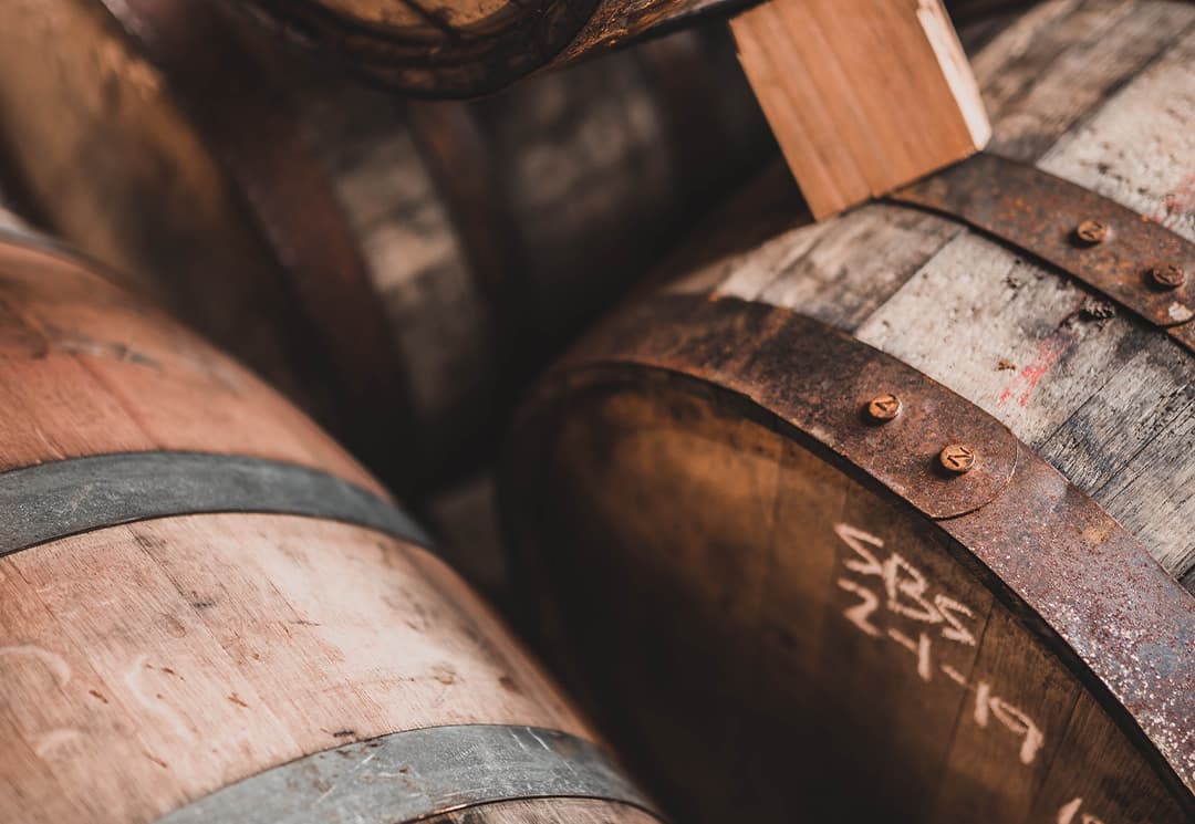 Whiskyfässer im Reifelager, mit Kreide beschriftet